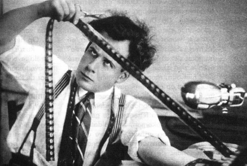 portrait d'Eisenstein en noir et blanc regardant les vignettes d'une pellicule de cinéma.